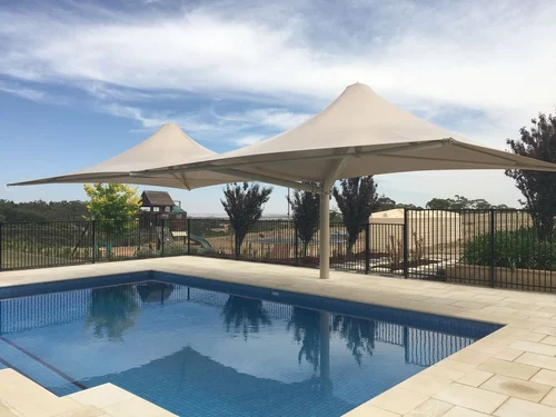 Tensile shade canopies over a swimming pool